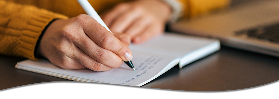 person writing in notebook