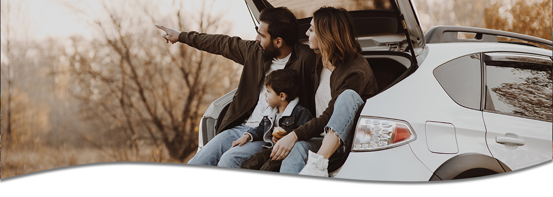 Family sitting the the trunk of an SUV