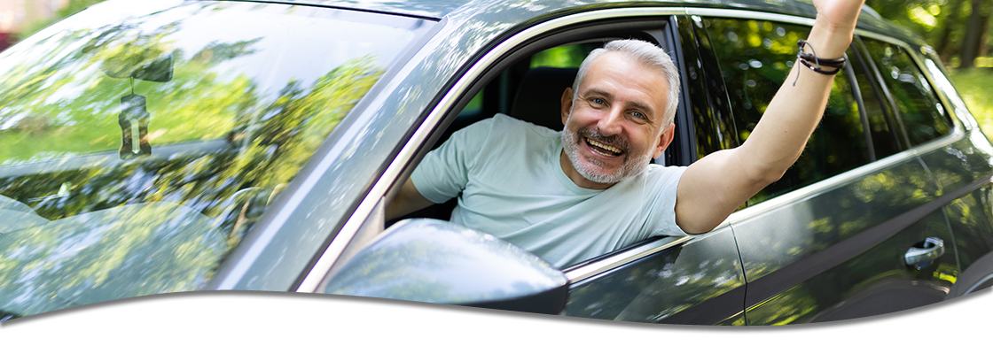 Man waving out car window happily