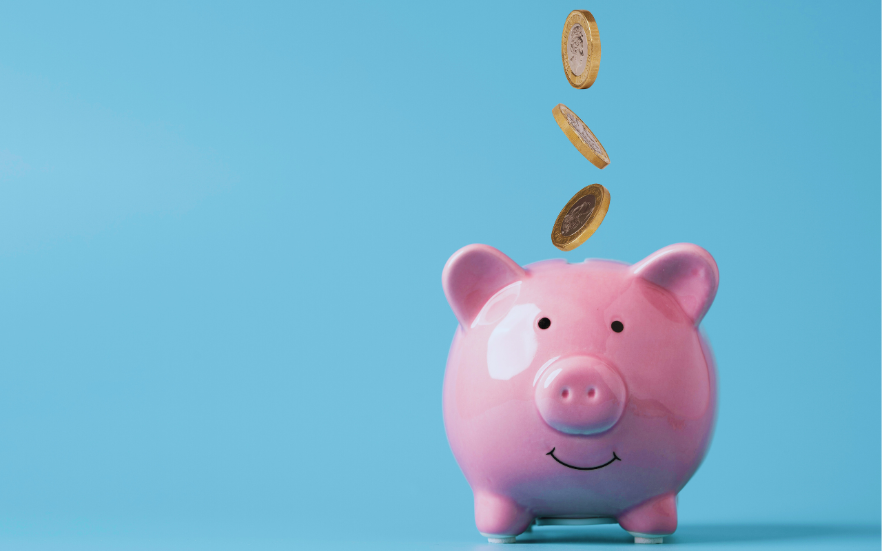 Coins falling into a piggy bank