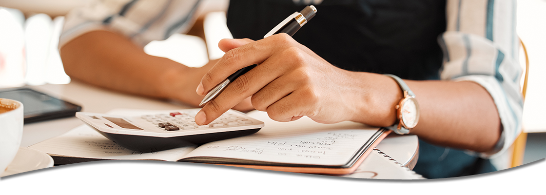 person using calculator and pen, making notes