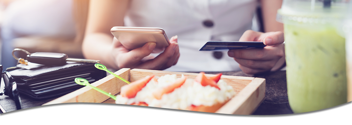 Individual on phone and card while at a restaurant