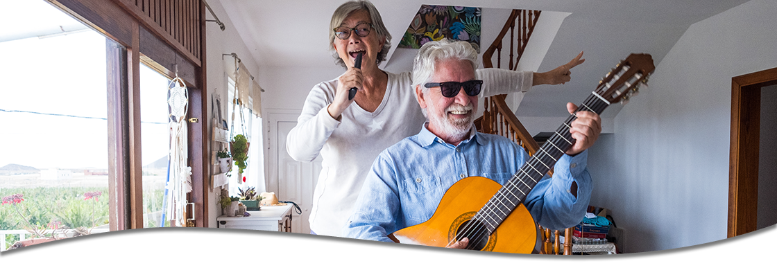 Older couple being goofy and singing in their home